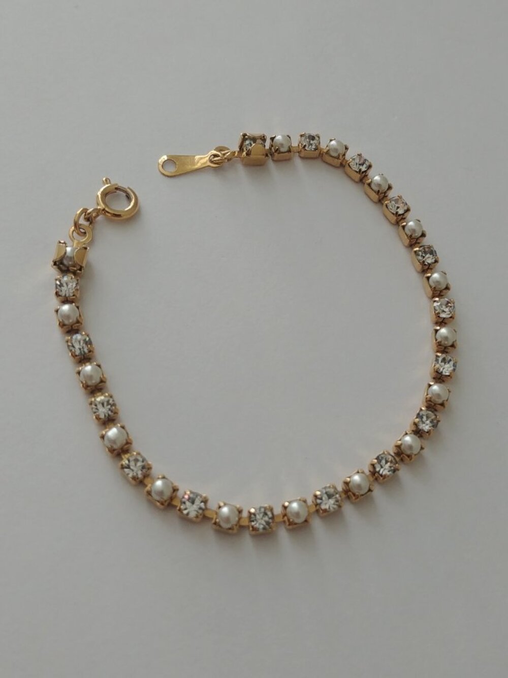 Dainty gold tone tennis bracelet with alternating faux pearl and diamonds